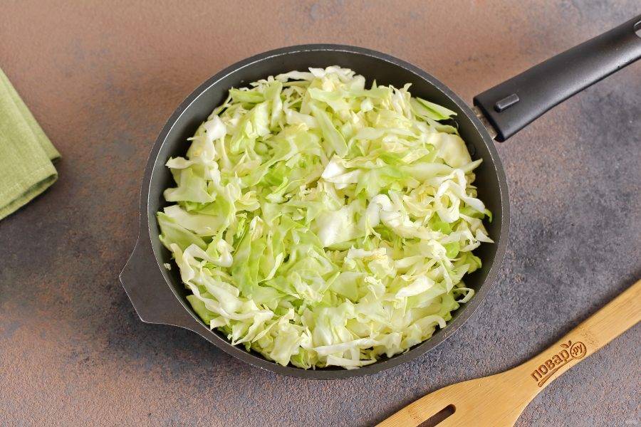 В сковороде разогрейте масло, выложите нашинкованную тонко капусту и тушите до мягкости.