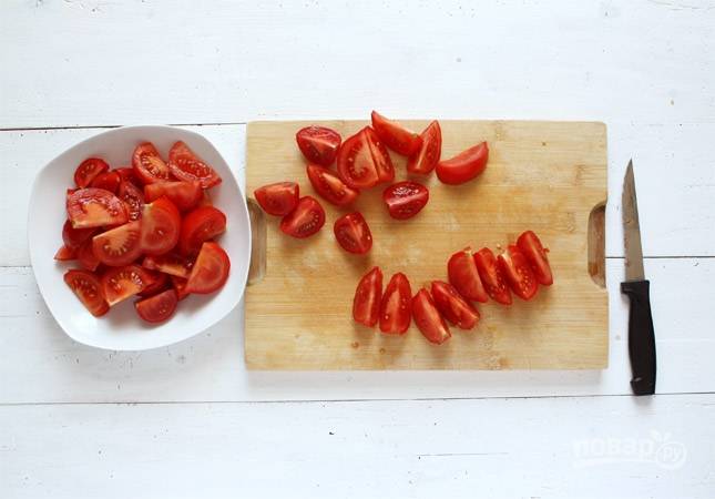 Промытые помидоры нарежьте крупными дольками. Чеснок почистите и раздавите ножом.