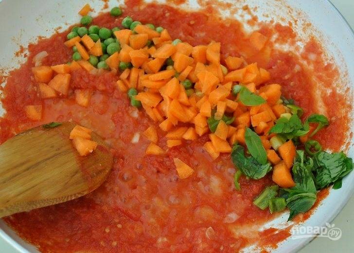 На оливковом масле обжарьте лук и чеснок, добавьте томатное пюре и замороженные овощи. Посолите и поперчите. Протомите соус 5-7 минут.