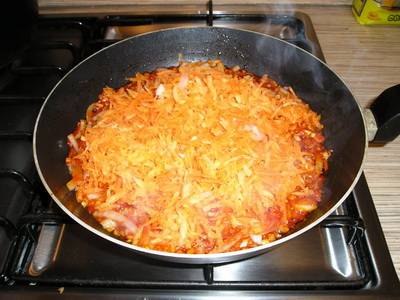 Когда лук станет мягким, добавляем в зажарку морковь и перемешиваем.