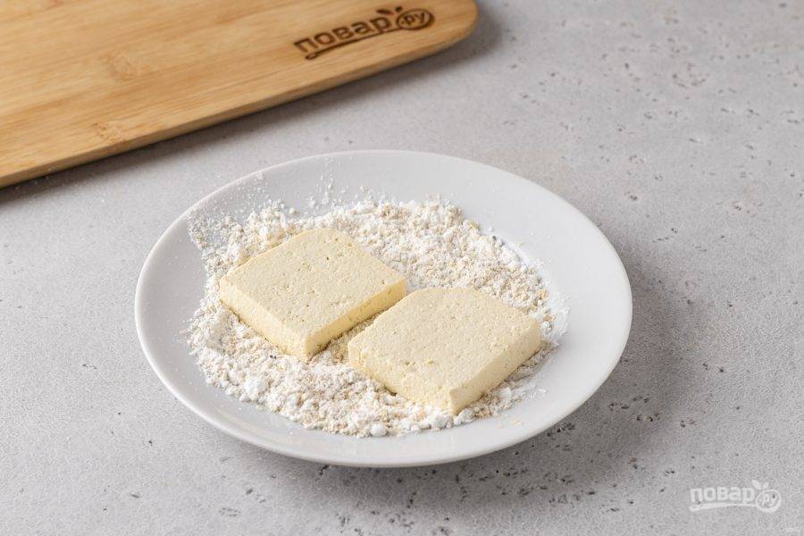 Разрежьте тофу на ломтики толщиной 1-1,5 см. Промокните бумажными полотенцами от влаги. Смешайте крахмал, пищевые дрожжи, соль и перец. Обваляйте в получившейся смеси ломтики тофу.