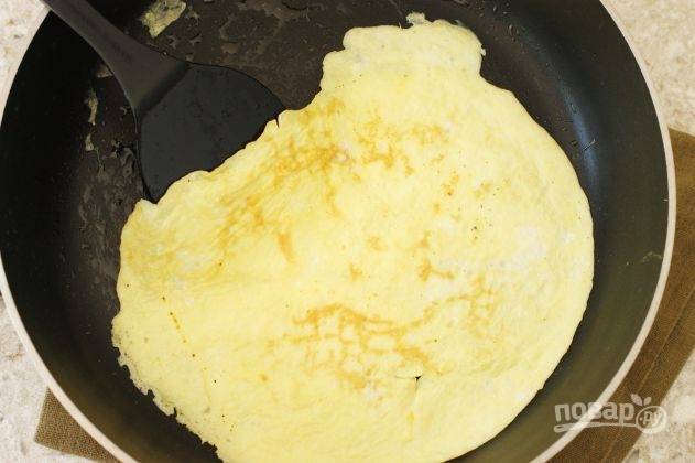 В емкости взбейте 2 яйца со щепоткой соли. На разогретой с маслом сковороде зажарьте яичный блинчик с двух сторон по 30 секунд.