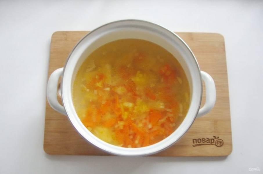 Лук и морковь выложите в кастрюлю с картофелем и бульоном. Продолжайте варить суп.