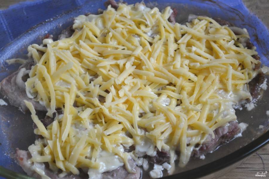 Достаньте мясо из духовки, присыпьте натертым на крупной терке твердым сыром и отправьте в духовку еще на 10-15 минут. Готовность мяса проверьте спичкой, если она хорошо входит в мясо, значит — оно готово. Как только сыр расплавится и образует аппетитную корочку, доставайте блюдо из духовки.