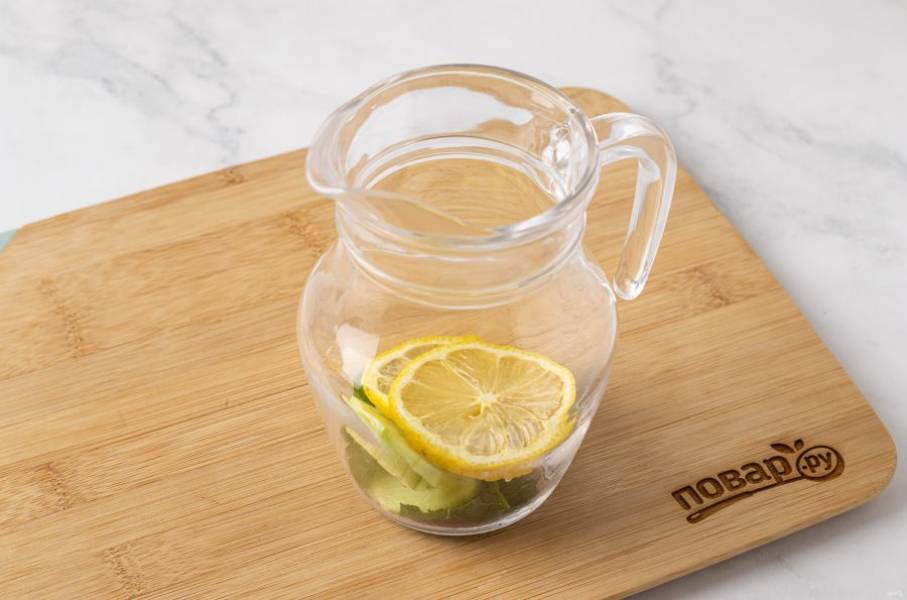 В кувшин переложите имбирь, мяту, лимон и огурец. Немного подавите их, чтобы они пустили сок.