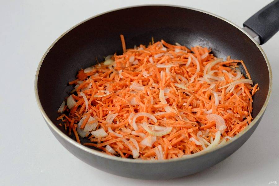 Нарежьте лук полукольцами, морковь натрите на крупной терке. Обжарьте на растительном масле в течение 1-2 минуты.