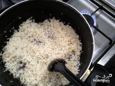 Рис промойте, обсушите. Затем добавьте его в сковороду, немного перемешайте.