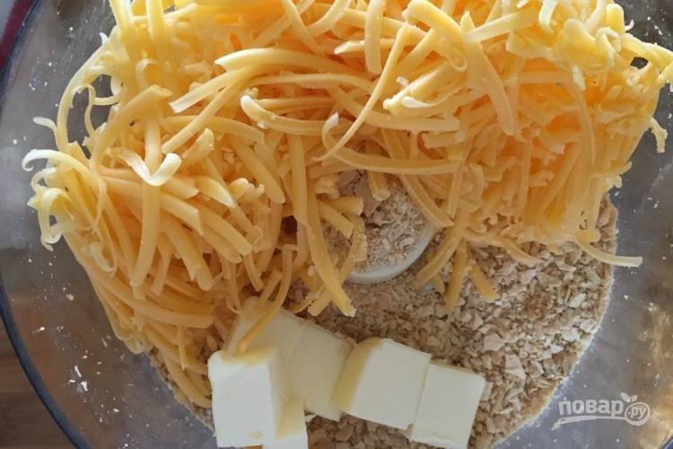 2. В комбайне измельчите половину сыра, масло и панировочные сухари.