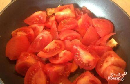 Очищенные помидоры нарезаем на дольки и добавляем на сковороду. Тушим на небольшом огне до тех пор, пока все овощи не станут мягкими.