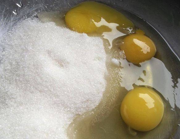 В миску, в которой будем делать тесто, вбиваем яйца. Один белок оставим - он нам понадобится в самом конце. Добавляем к яйцам сахар и взбиваем все до легкой пенки.