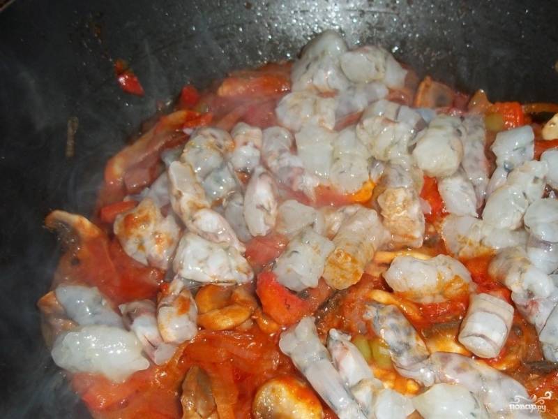 2. Посолите, по вкусу поперчите. Перемешайте и добавьте томатную пасту и орегано. Опять перемешайте. Тушите 5-7 минут (лучше под крышкой). Затем выложите креветки в сковородку, предварительно их разрезав на две равные части.