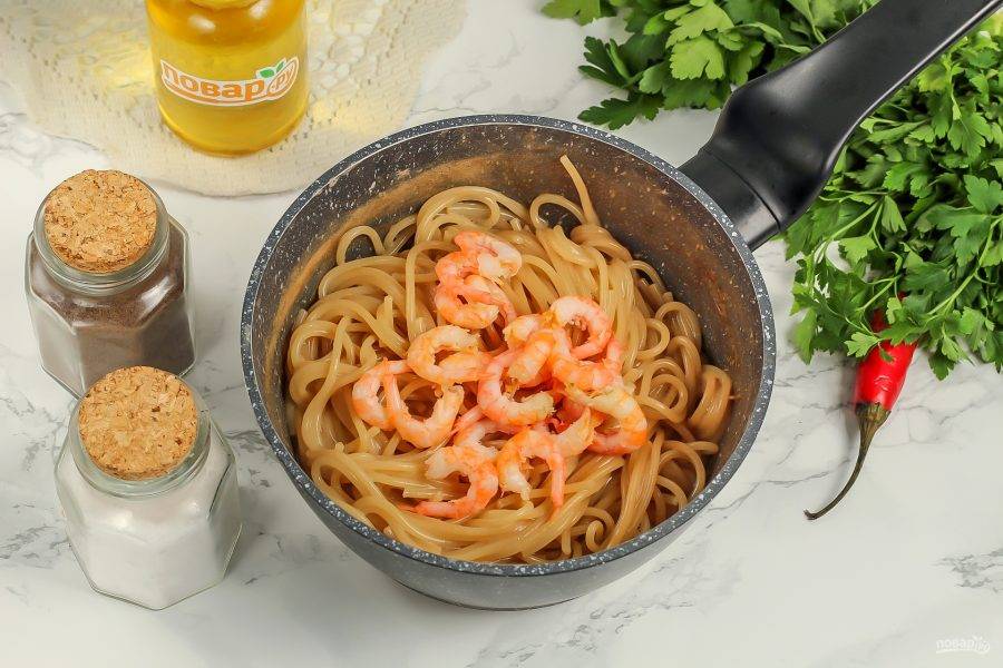 Когда спагетти будут практически готовы, добавьте в емкость очищенные креветки. Протомите еще 1-2 минуты, перемешав содержимое емкости.