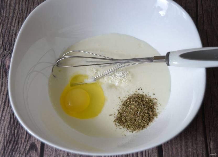 В миску для замешивания теста влейте кефир, добавьте соль, разрыхлитель для теста, сухие базилик и орегано.