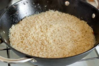 Готовим 30 минут, огонь средний. Предварительно промытый и замоченный рис выкладываем сверху ровным слоем. Аккуратно вливаем литр кипятка. Варим до готовности риса, не перемешивая. Когда выпарится вода, добавляем еще немного зиры, накрываем крышкой и готовим на медленном огне 10-15 минут.