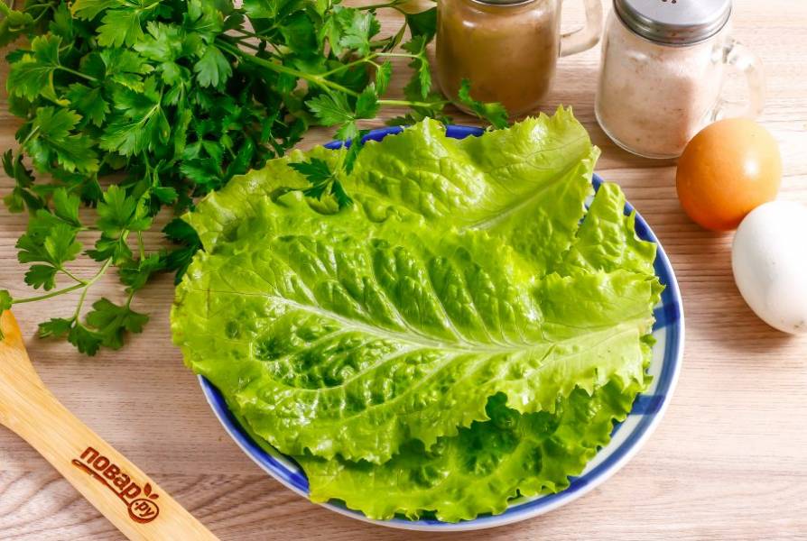 Промойте листья салата в воде, стряхните лишнюю влагу и выложите на тарелку.