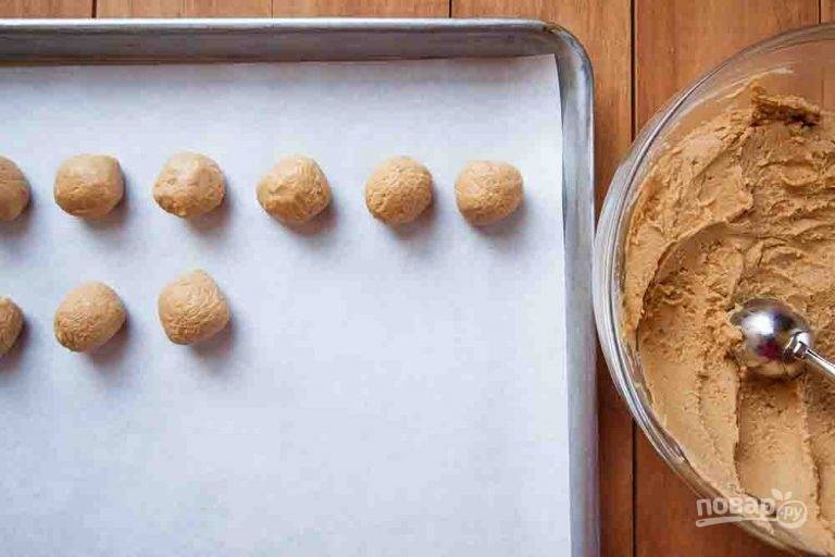 3.	Возьмите ложкой немного арахисовой массы, сформируйте из нее шарики и выложите на поднос, застеленный пергаментной бумагой. Проделайте это со всей арахисовой массой. Положите полученные шарики в холодильник минимум на 1 час.