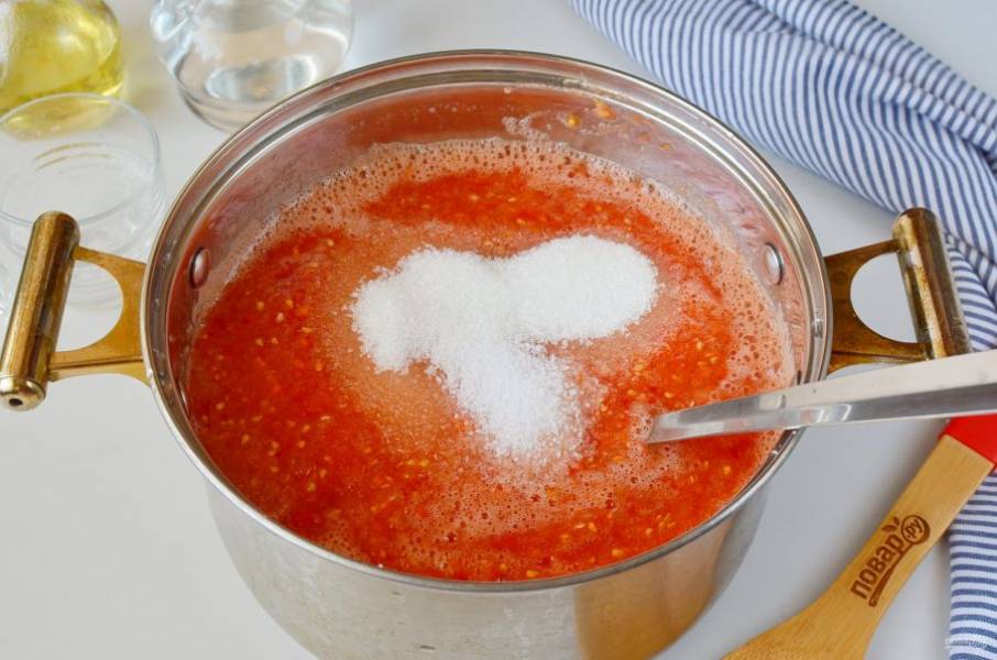 Перелейте аджику в глубокую кастрюлю, добавьте сахар и соль. Количество сахара 150-200 грамм, в зависимости от кислоты томатов, я всегда добавляю 200 грамм.