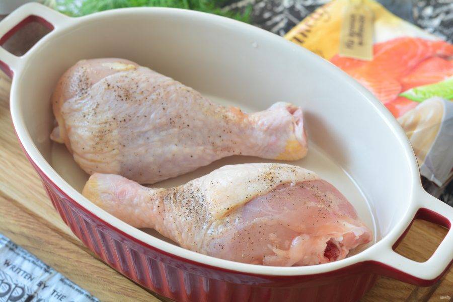 Смажьте форму для запекания маслом, выложите куриные ножки и добавьте специи по вкусу.