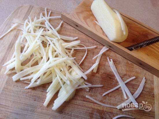 Очистим картофелину среднего размера, помоем и обсушим. А затем нарежем на тонкие полоски с помощью терки для корейской морковки.