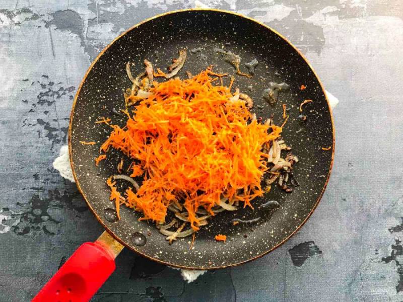 Добавьте тертую морковь и жарьте 4-5 минут.