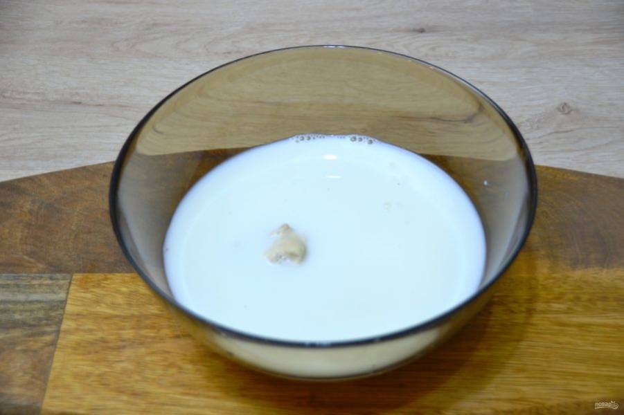 Влейте в миску теплое молоко, размешайте, чтобы пшеничная закваска растворилась в молоке. 