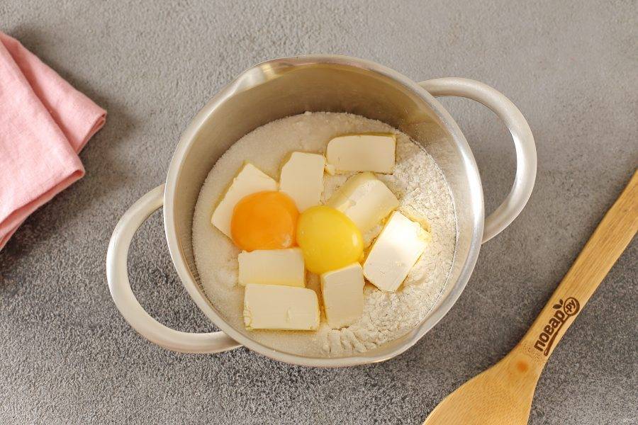 В глубокой миске соедините муку, соль, сахар, нарезанное кубиками масло и желтки.