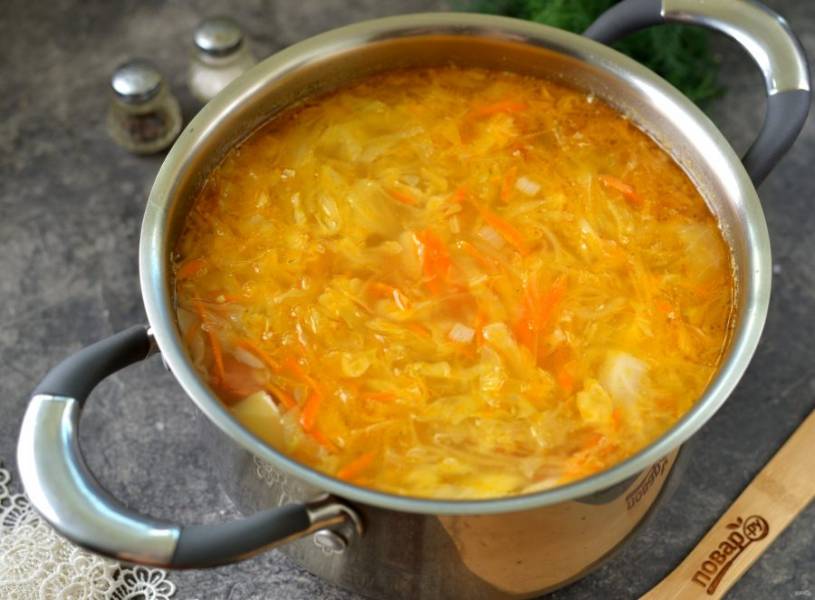 В процессе добавьте в суп измельченный чеснок, посолите и поперчите суп по вкусу, при желании отрегулируйте кислоту сахаром. Иногда в этот вариант капустняка добавляют томатную пасту. 