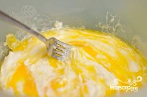 Растопите масло. Вылейте его в миску, туда же сметану и одно яйцо. Посолите и добавьте разрыхлитель для теста. Всё перемешайте.