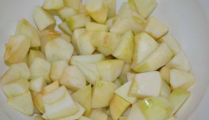 Яблоки промойте и порежьте кубиками, затем засыпьте сахаром, чтобы они выделили сок.