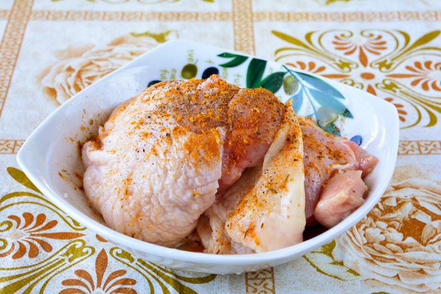 Промойте куриные бедрышки, посолите, поперчите по вкусу, добавьте специи для курицы.