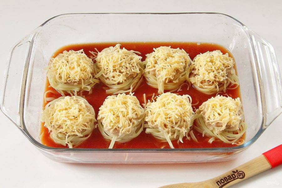Залейте гнезда томатным соусом и посыпьте тертым сыром. Запекайте при 180-200 градусах около 45 минут. Если будет необходимо, в процессе добавьте еще немного соуса или любой бульон. Гнезда должны быть в соусе больше, чем наполовину.