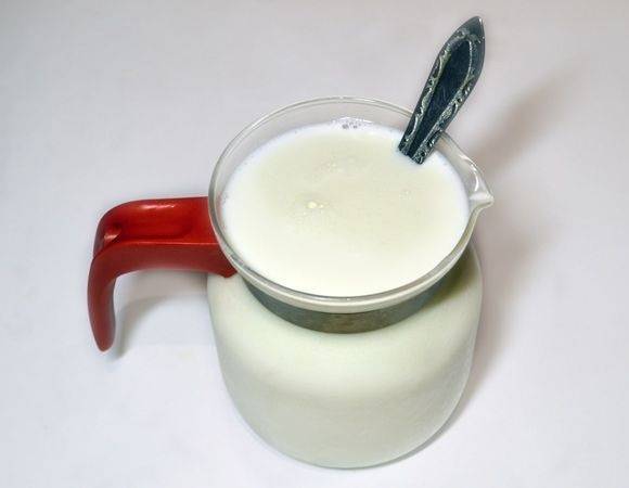 2. Нагрейте молоко немного (сырое лучше прокипятить, а затем охладить), добавьте сахар и йогурт. Как следует перемешайте, чтобы масса была однородной. 
