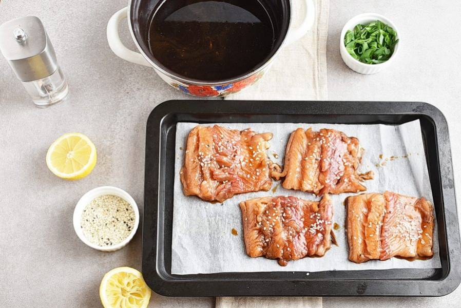 Выложите филе лосося на застеленный пергаментом лист для выпечки и присыпьте сверху ложечкой кунжута.