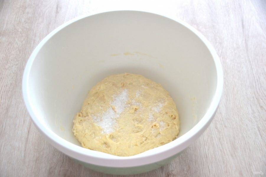 Через 30 минут добавьте соль, замесите тесто. Месите руками не менее 10-13 минут. Накройте пищевой пленкой, поставьте в теплое место для брожения на 3 часа.