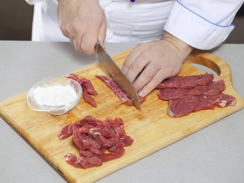Мясо промойте и обсушите, нарежьте тонкими ломтиками и обваляйте в муке.