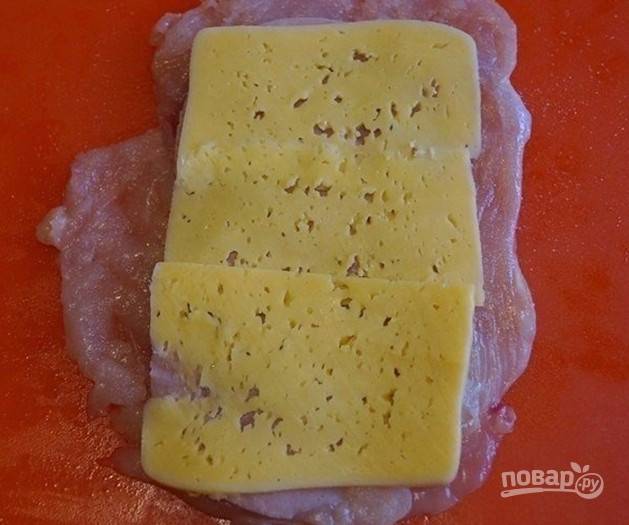 Сыр также нарежьте ломтиками. Уложите его на ветчину.