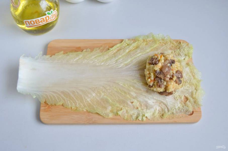 8. Положите листок капусты, на край - пару столовых ложек начинки.