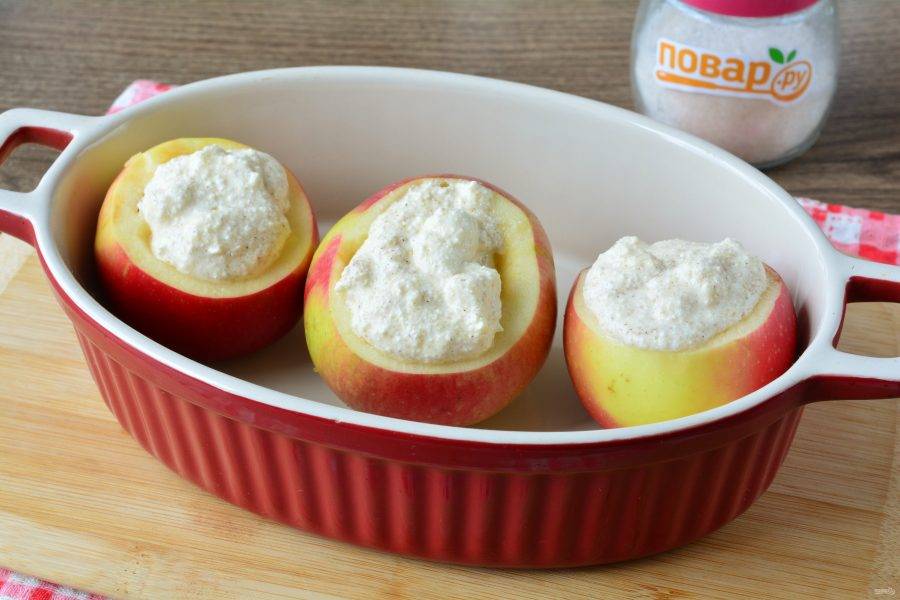 Нафаршируйте яблоки творожной начинкой. Выложите яблоки в форму для запекания.