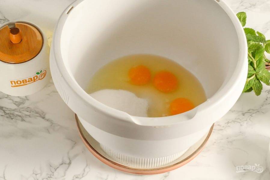Вбейте куриные яйца в чашу кухонного комбайна или миксера, всыпьте соль и сахарный песок. По желанию можете всыпать щепотку ванильного сахара или ванилина. Взбейте все на самой высокой скорости техники примерно 3-4 минуты.