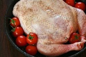 8. Отправляем нашу курочку в духовку на один час. Огонь лучше убавить, а рядом можно выложить помидоры и другие овощи. Так у нас получится фаршированная курица без костей в домашних условиях и овощами.