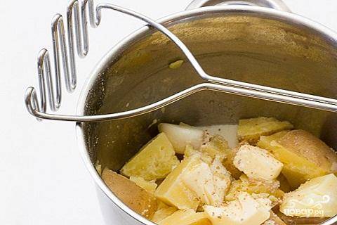 2.	В кастрюле вскипятите воду, посолите ее  и сварите в ней картофель и зубчики чеснока до готовности. Добавьте горячее молоко и сливочное масло, и с помощью блендера или толкушки измельчите его до состояния пюре. Добавьте  размятую моцареллу и твердый сыр, что остался. Хорошо перемешайте и добавьте по вкусу соль и перец.