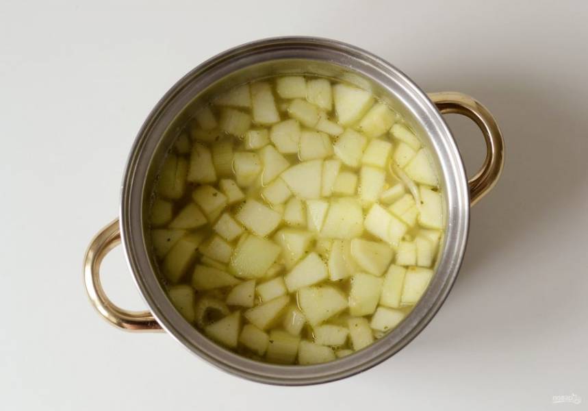 Влейте овощной бульон. Доведите до кипения и варите на медленном огне, пока картофель не станет мягким.
