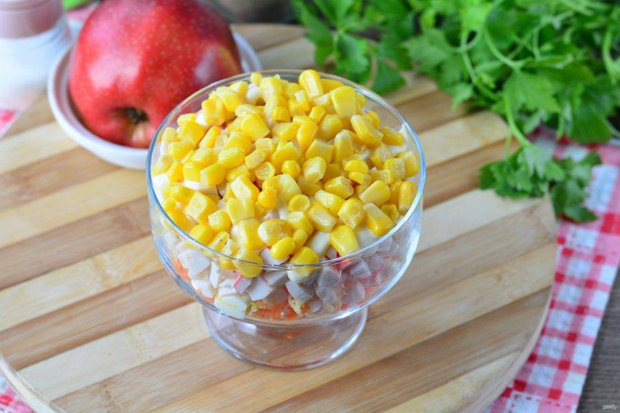 Завершите салат слоем консервированной кукурузы.