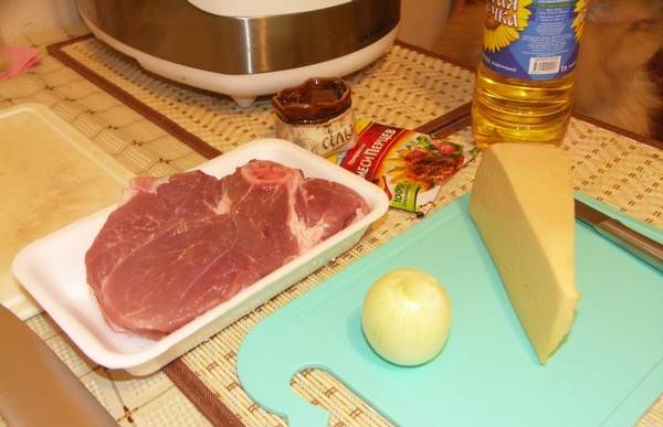 Режем средними кусочками свинину. Лук нарезаем полукольцами, помидоры - кружочками, а сыр трем на терке.
