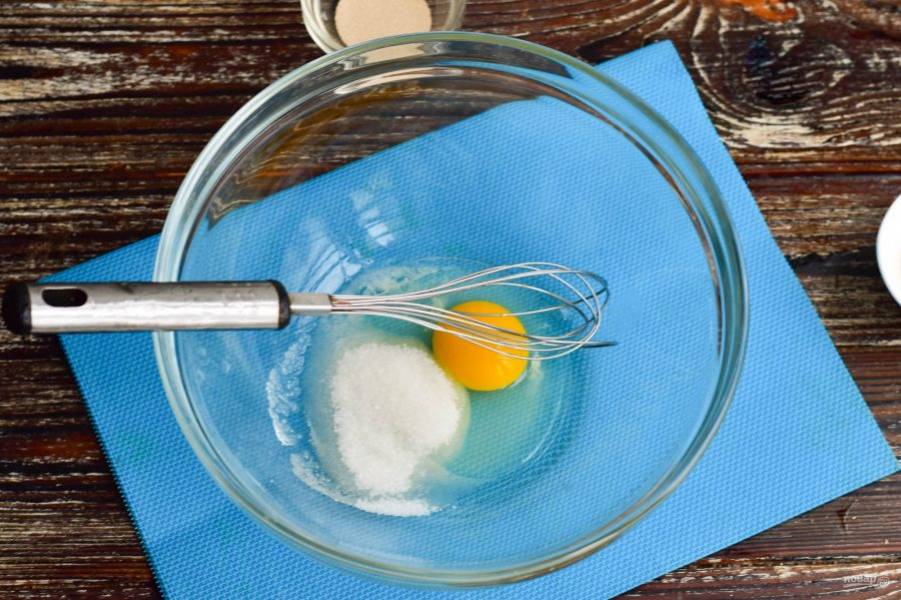 В миску вбейте куриное яйцо, всыпьте соль и сахар (3 ст. ложки). Перемешайте.
