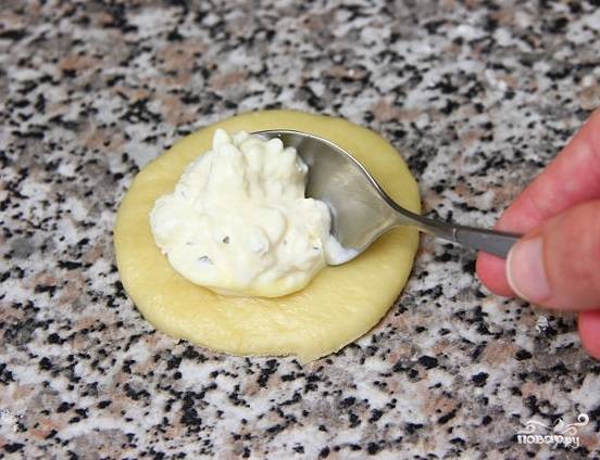 8. Сыр натрите в миску, вбейте туда же одно яйцо и всыпьте базилик, все перемешайте до однородной массы. Чайную ложку начинки выложите в центр кружка из теста.