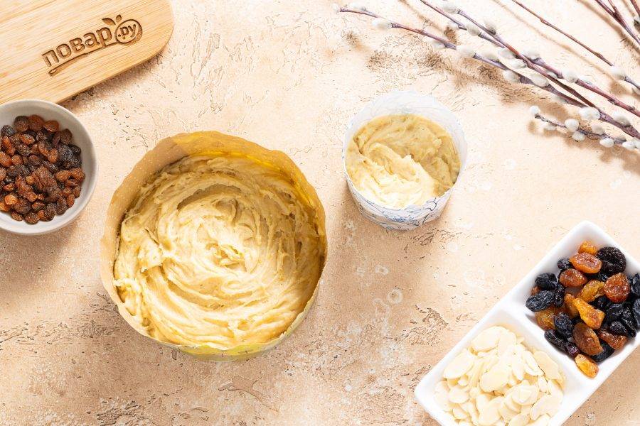 Разложите тесто по бумажным формочкам для куличей. Можно делать один большой или несколько маленьких. Выпекайте кулич в разогретой до 180 градусов духовке. Большой кулич будет готов примерно за 45-50 минут, а маленькие за 20-30. Готовность проверяйте деревянной шпажкой. Куличи не должны оставаться жидкими внутри. Если верх будет подгорать, то накройте кулич фольгой и выпекайте до готовности.