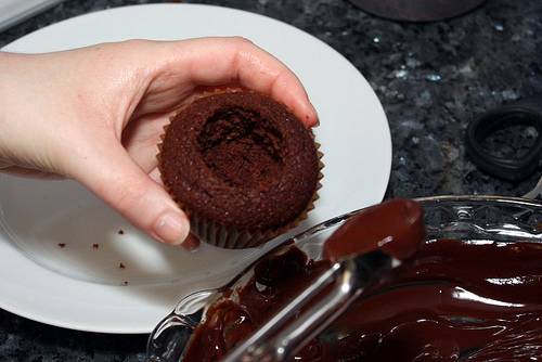4. Растопить на водяной бане сливочное масло и шоколад. Наполнить капкейк шоколадной глазурью примерно на половику. 