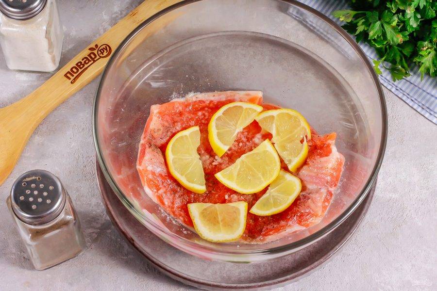 Ошпарьте лимон и нарежьте его половину ломтиками, удаляя косточки. Выложите на нарезку рыбы.