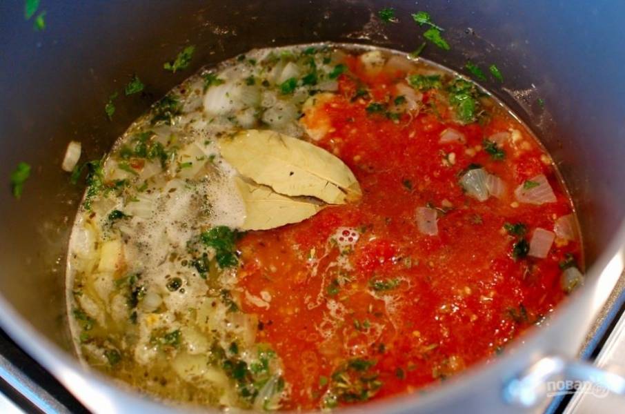 4. Томаты очистите от кожуры и нарежьте мелко (должно быть около 2-2,5 стаканов), добавьте их в кастрюлю, а также влейте вино, бульон, лавровый лист.